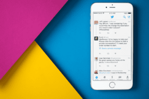 twitter account on a mobile with blue, yellow and pink background