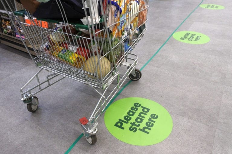 Social distancing floor stickers in a supermarket queue