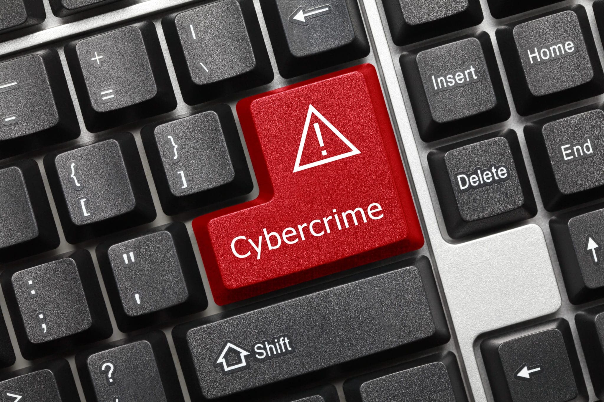 Close-up of a keyboard with a red key labelled "Cybercrime" and warning symbol.