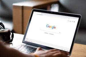 User browsing Google homepage on a laptop