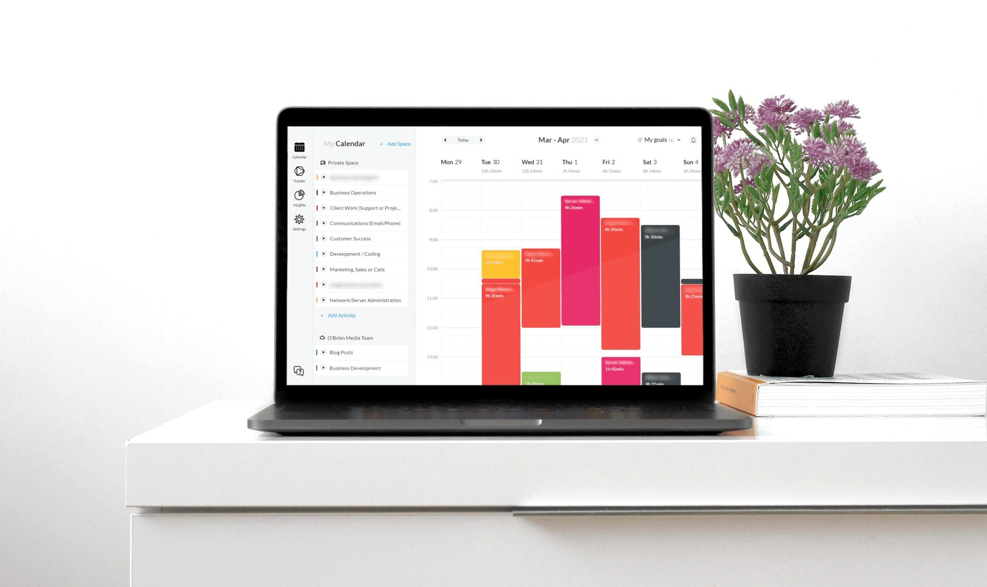 Laptop showing Timeular calendar next to a plant on a desk