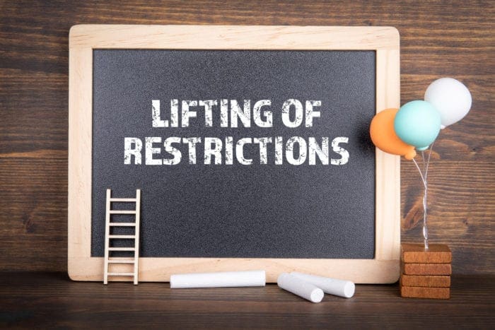 Chalkboard with “Lifting of Restrictions” written on it