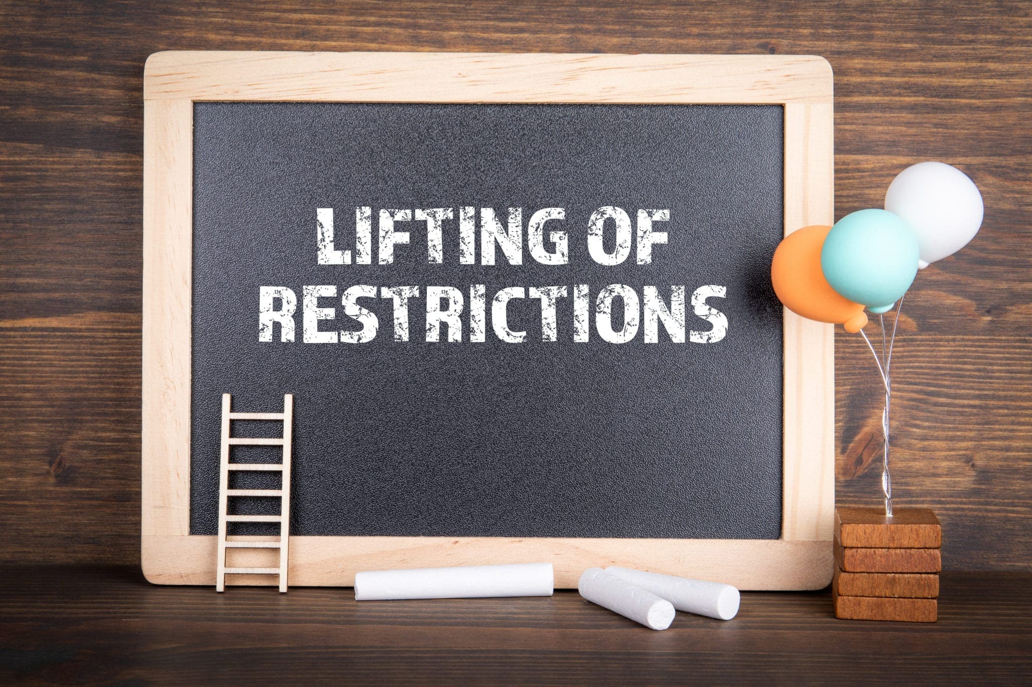 Chalkboard with “Lifting of Restrictions” written on it