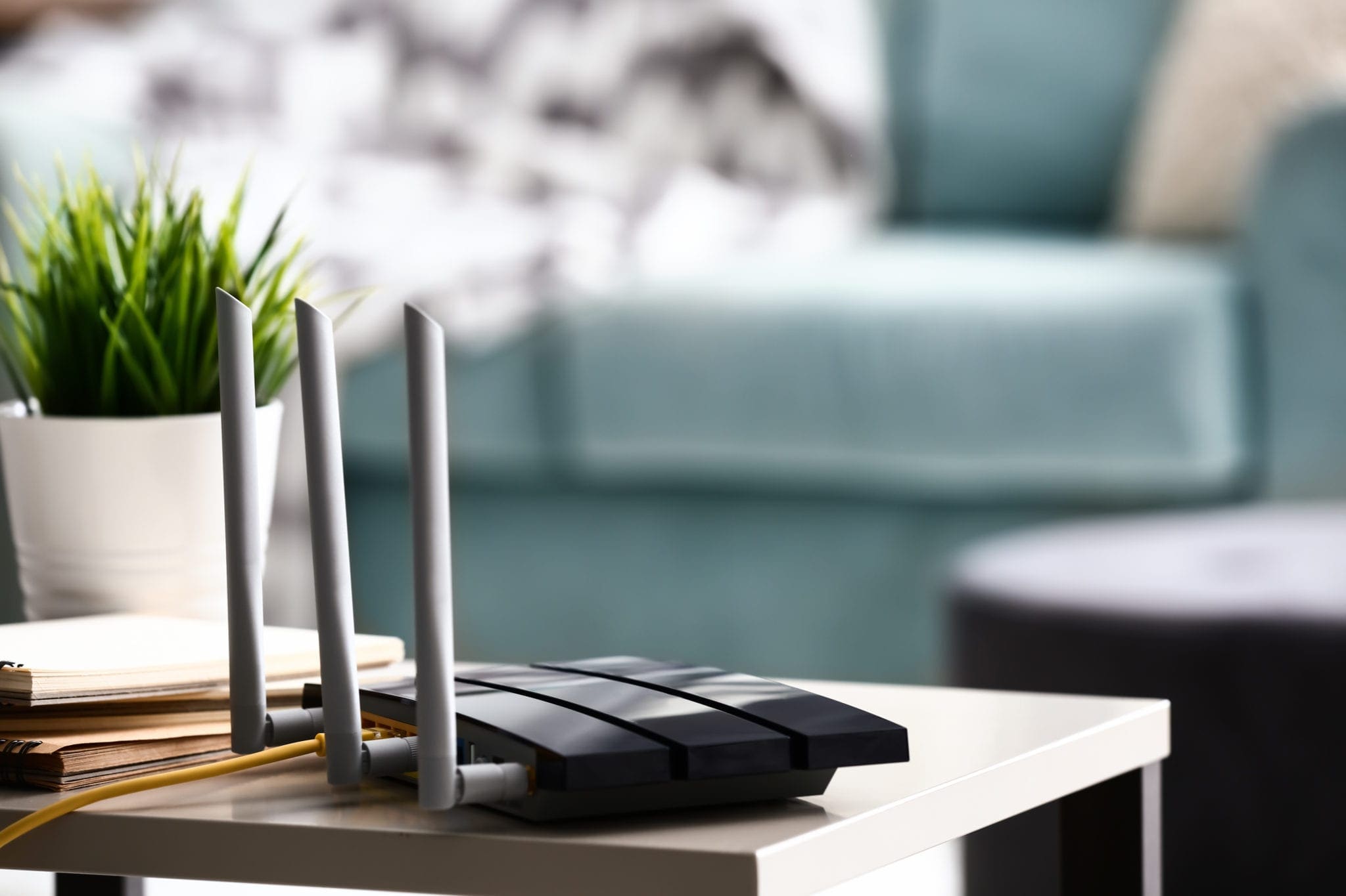 Wireless router with ethernet cables on a table in a home setting.