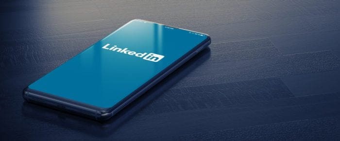 Smartphone displaying LinkedIn logo on screen, representing changes to the LinkedIn platform