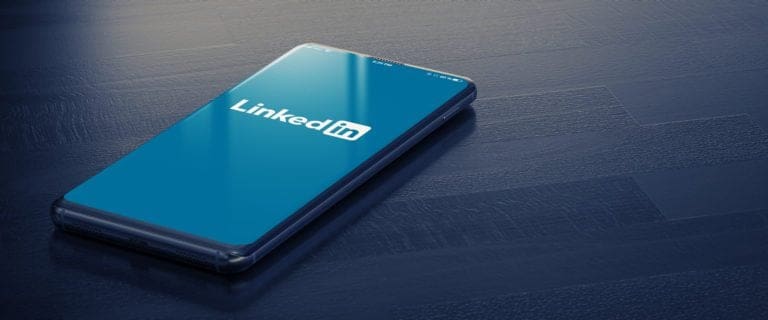 Smartphone displaying LinkedIn logo on screen, representing changes to the LinkedIn platform