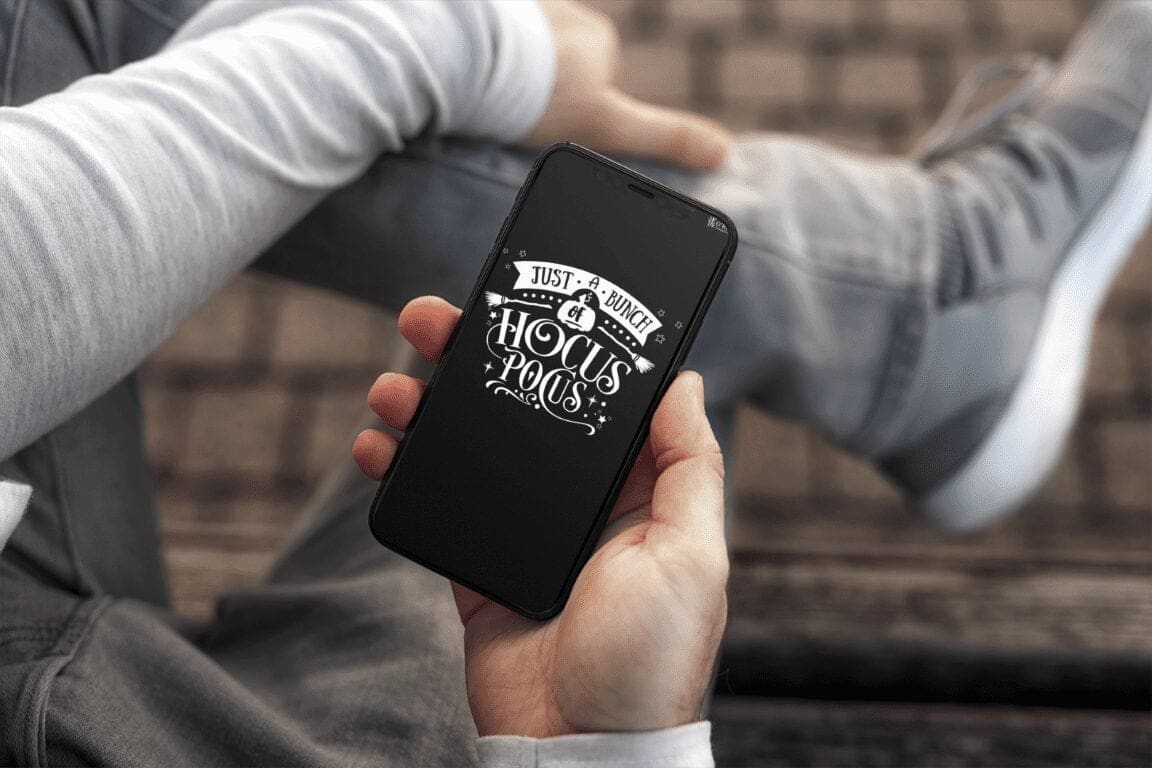 Person holding phone with "Just a Bunch of Hocus Pocus" Halloween quote wallpaper