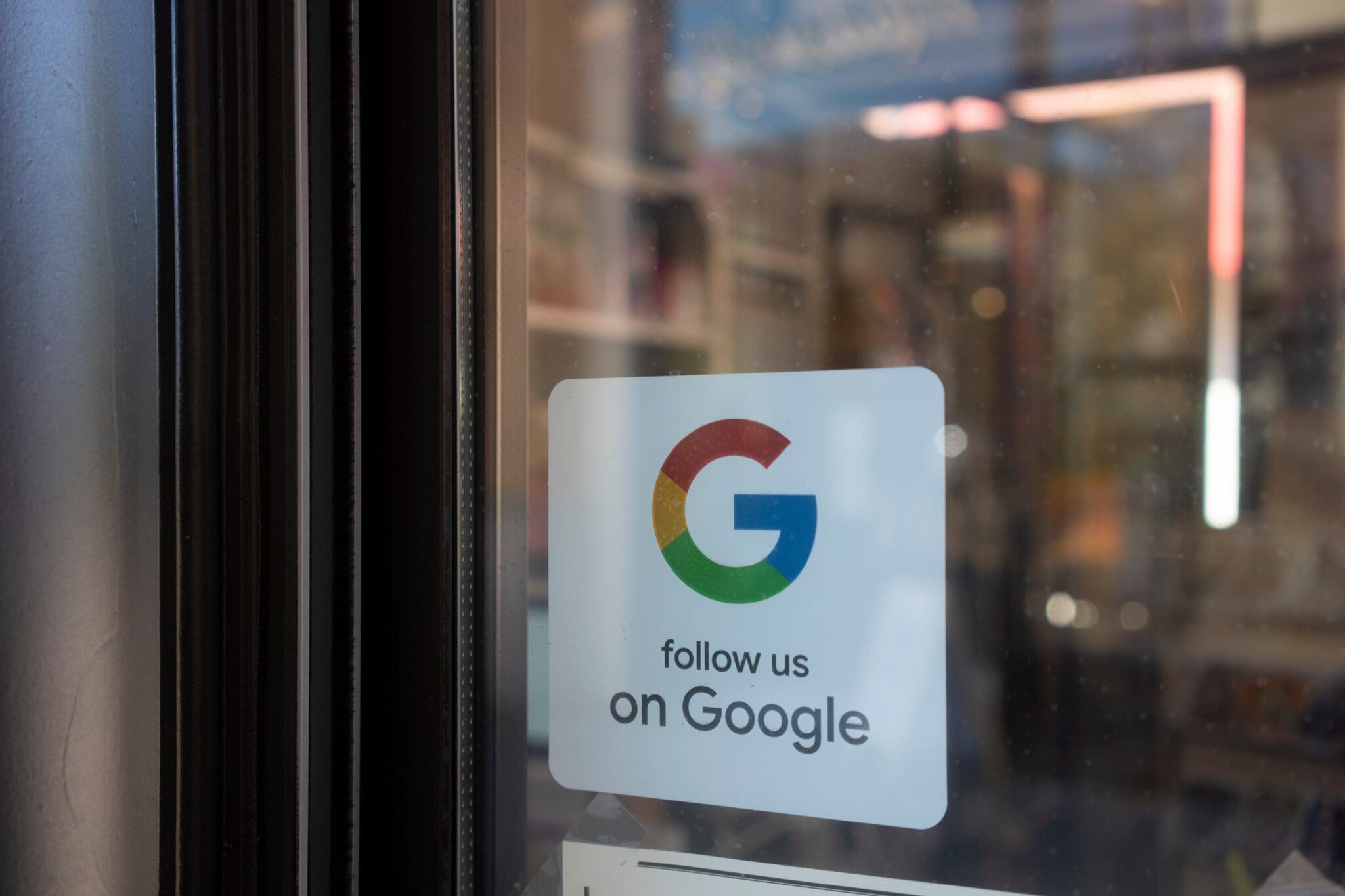 Google logo sticker on a shop window with the text "Follow us on Google"