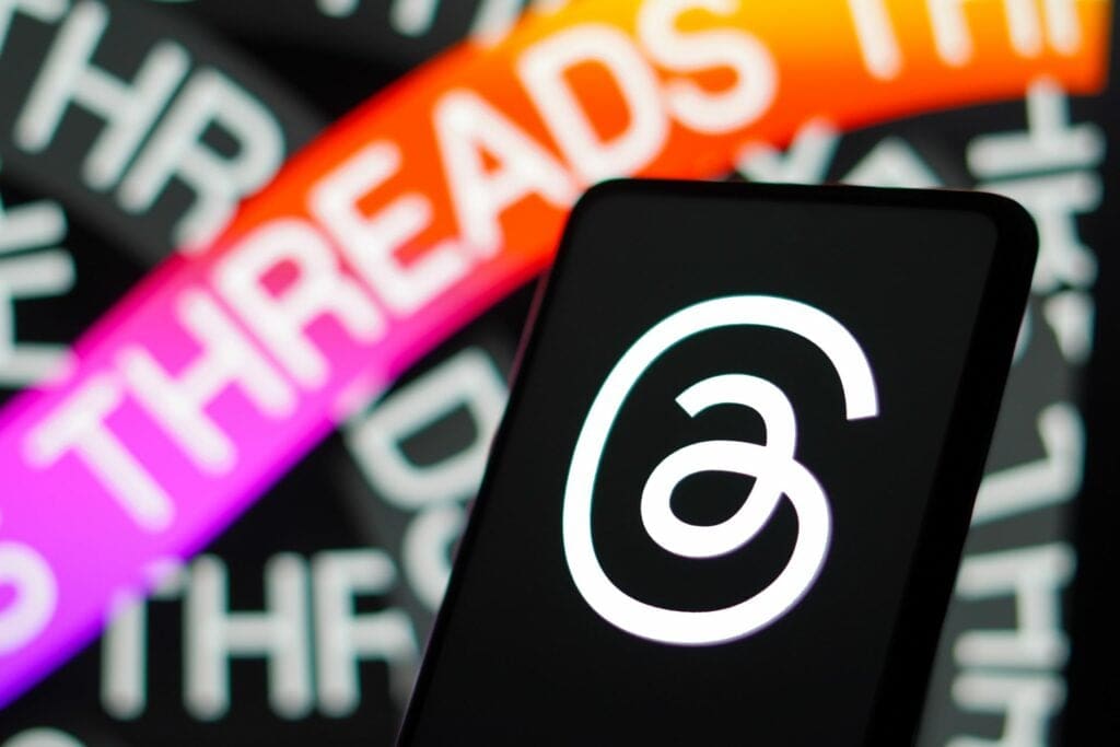 Threads app logo on a smartphone with vibrant THREADS text background