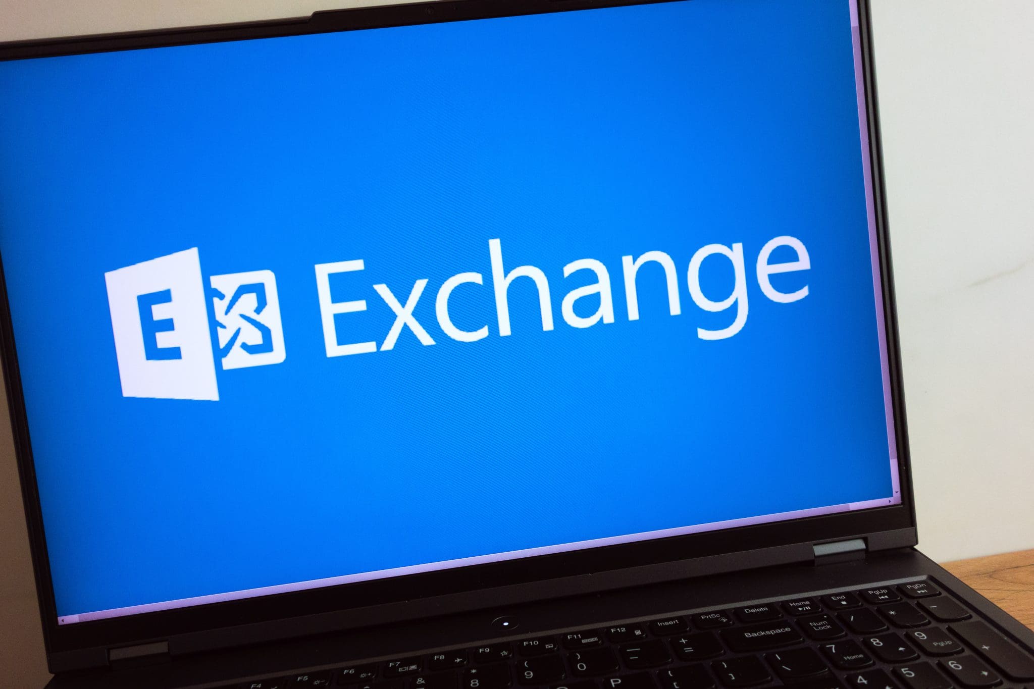 Laptop screen displaying Microsoft Exchange logo on a blue background