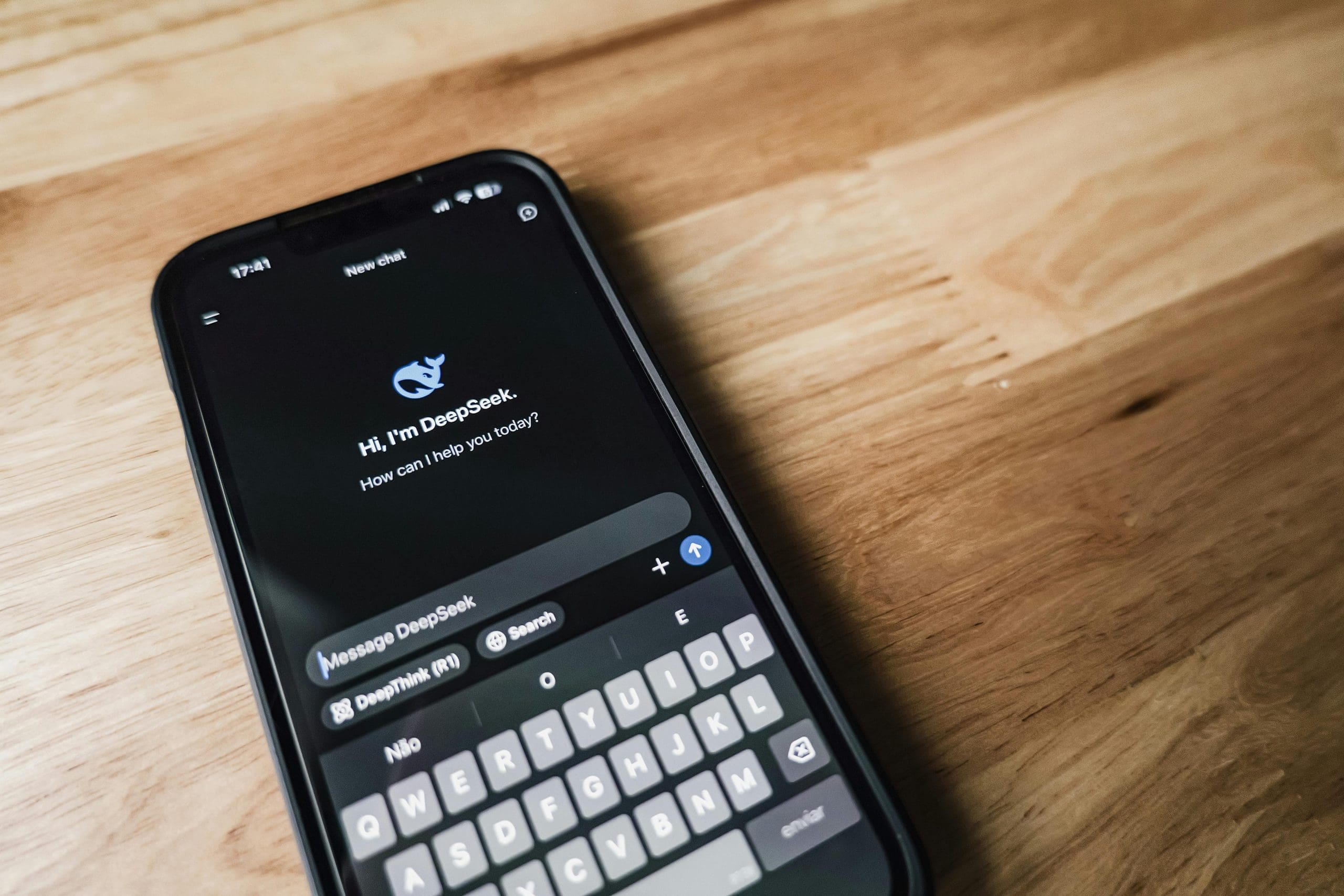 Silhouetted person using a laptop in a dark room with glowing code projected on a wall
