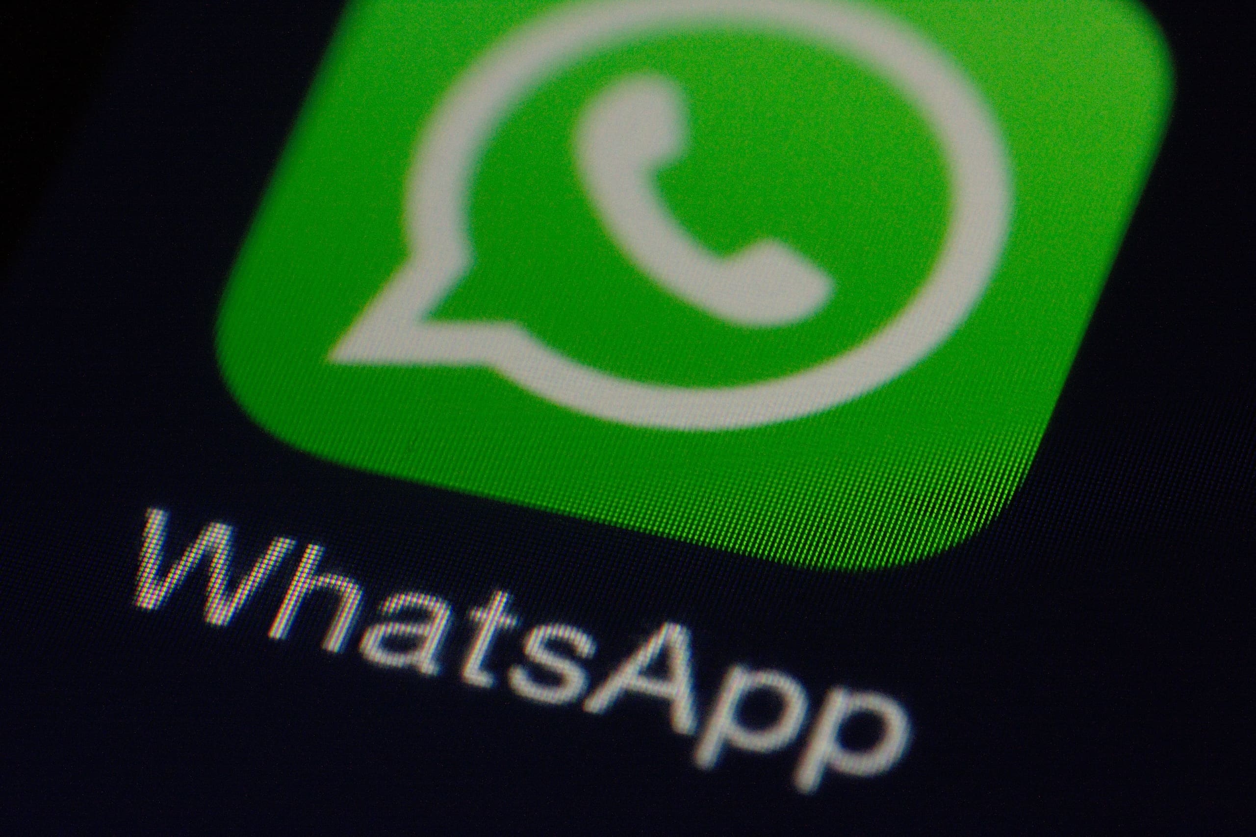 Smartphone screen displaying app icons with a focus on the green WhatsApp icon